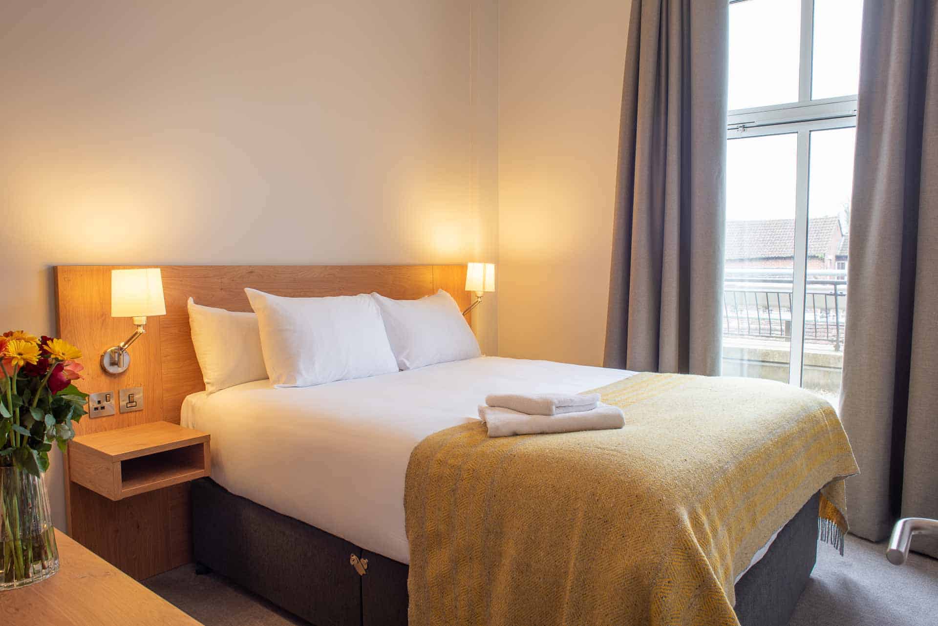 Slaapkamer met groot bed en uitzicht op de skyline bij PREMIER SUITES Reading