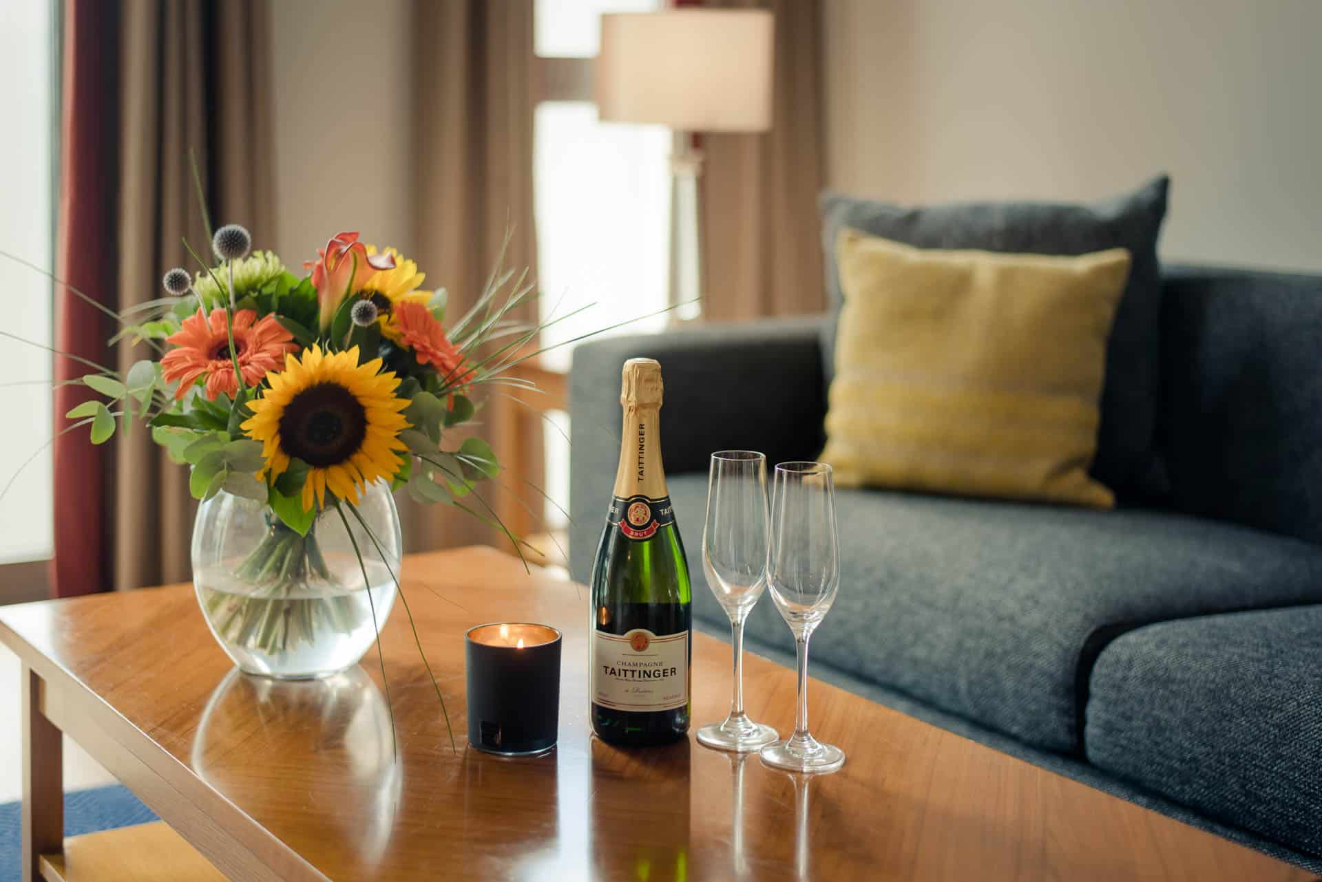 PREMIER SUITES Dublin Sandyford (living room couch and wine with glasses and flowers)