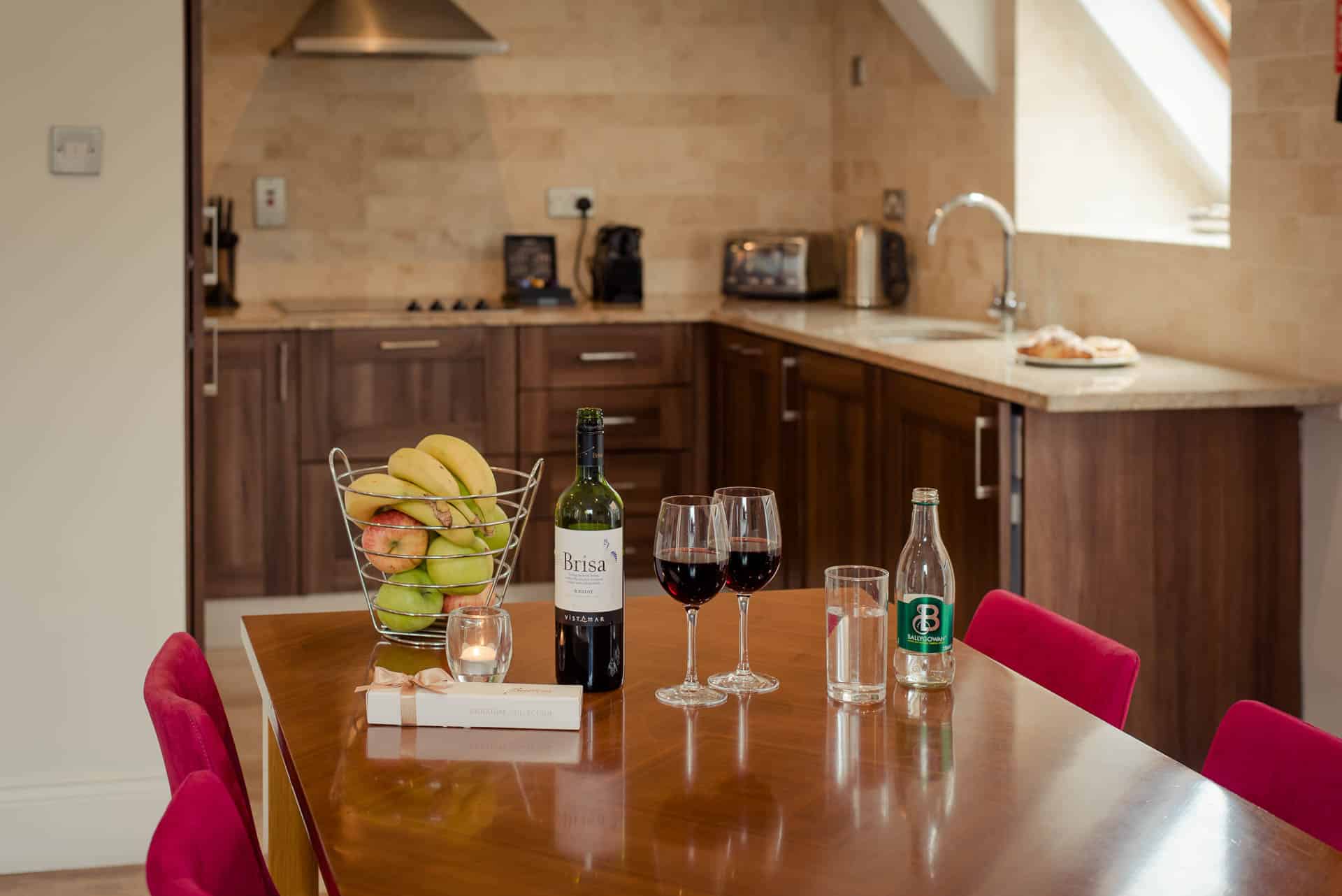 PREMIER SUITES PLUS Dublin Leeson Street kitchen table with fruit and wine