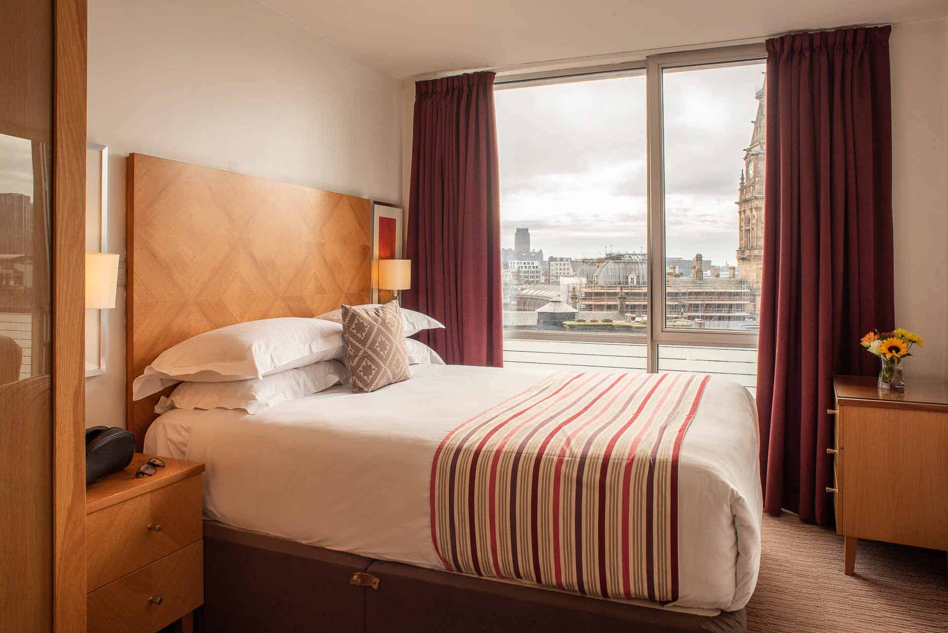 Geräumiges Schlafzimmer mit Tageslicht und Blick auf die Stadt im PREMIER SUITES Liverpool