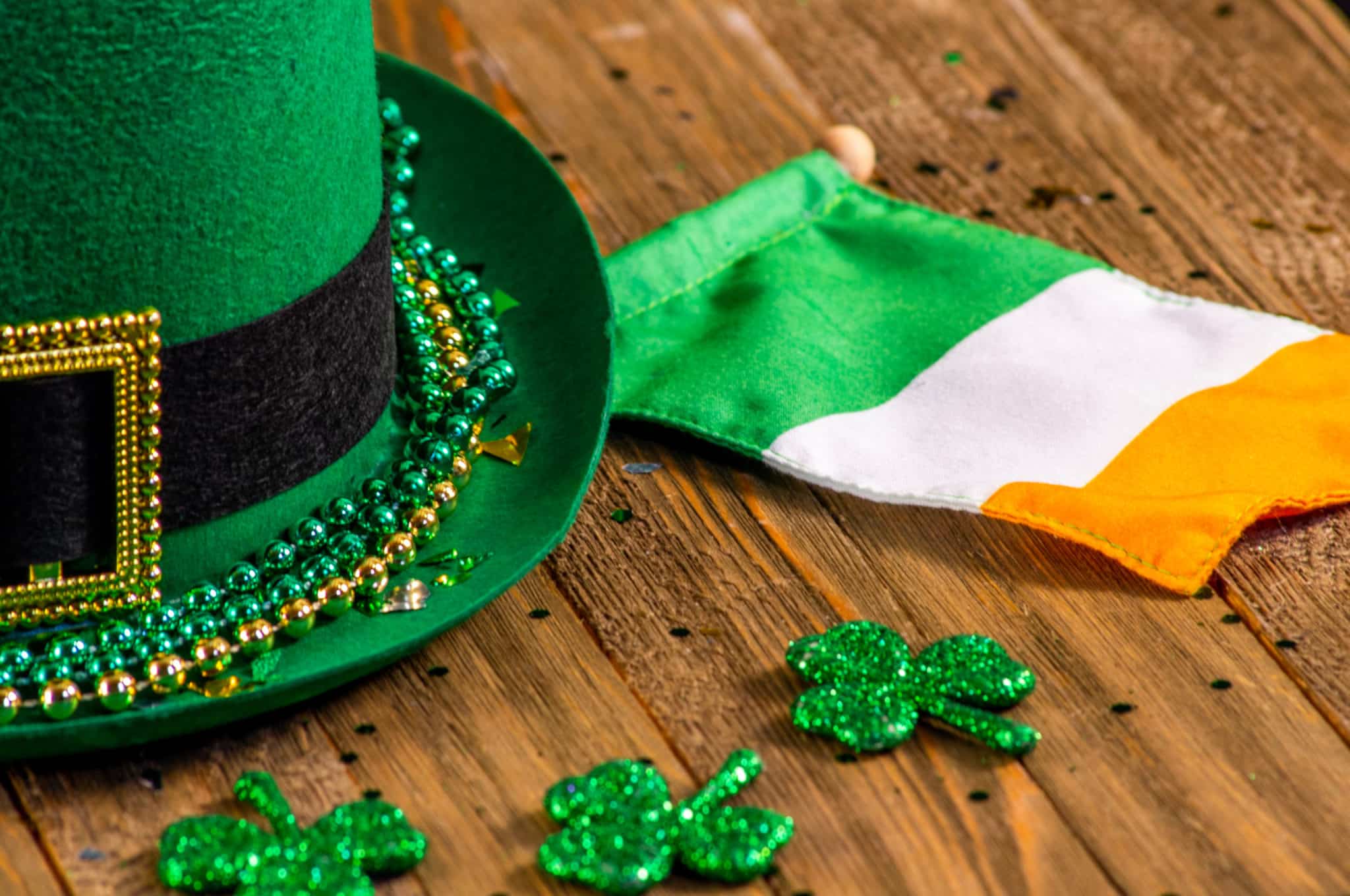Articles sur le thème de la Saint-Patrick, tels qu'un chapeau vert, un drapeau irlandais et des trèfles scintillants.