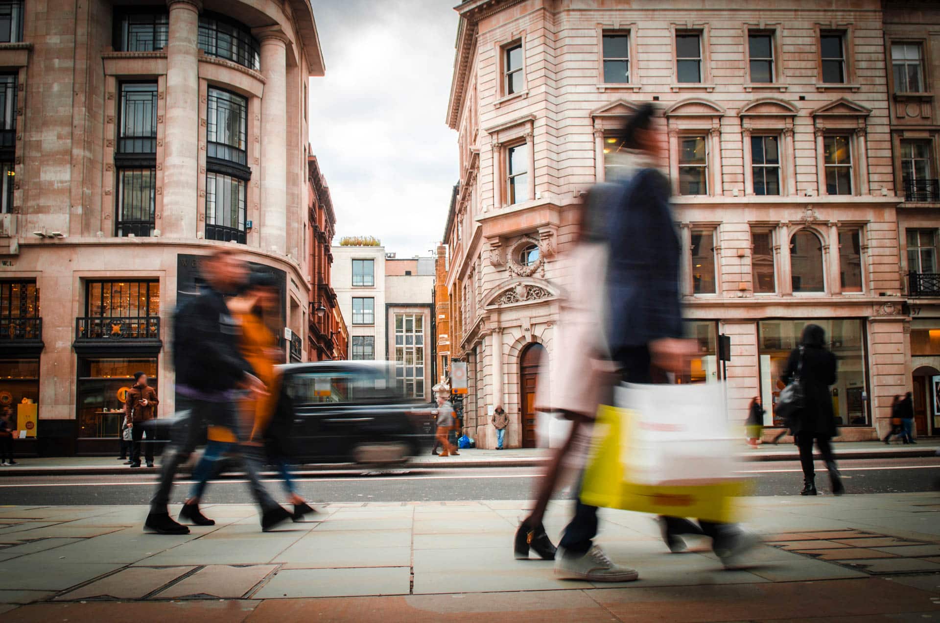 Bewegungsunscharfe Shopper mit Einkaufstaschen auf der Regent Street, London.