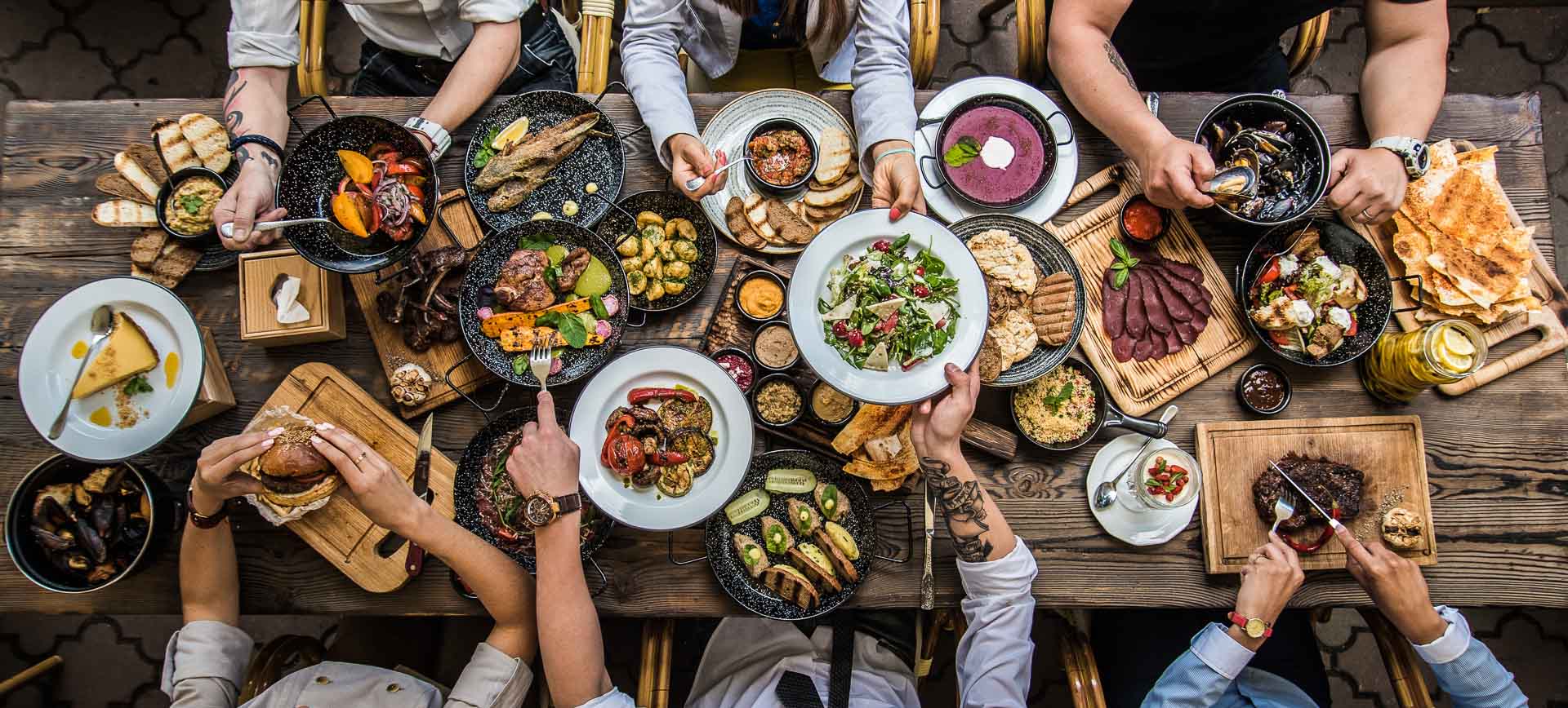 Tafel met eten, en vrienden eromheen verzameld.