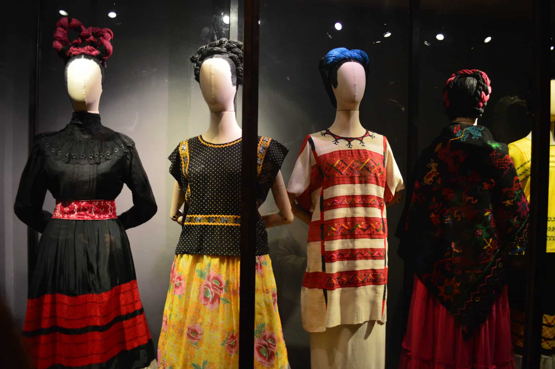 Mannequins on display wearing old, vintage clothing in what seems to be a museum