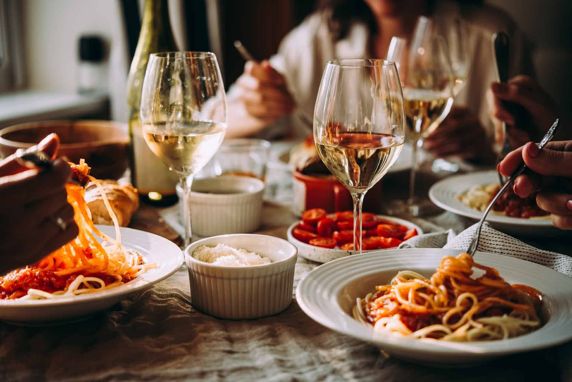 Vrienden hebben een pasta diner thuis of in een restaurant.
