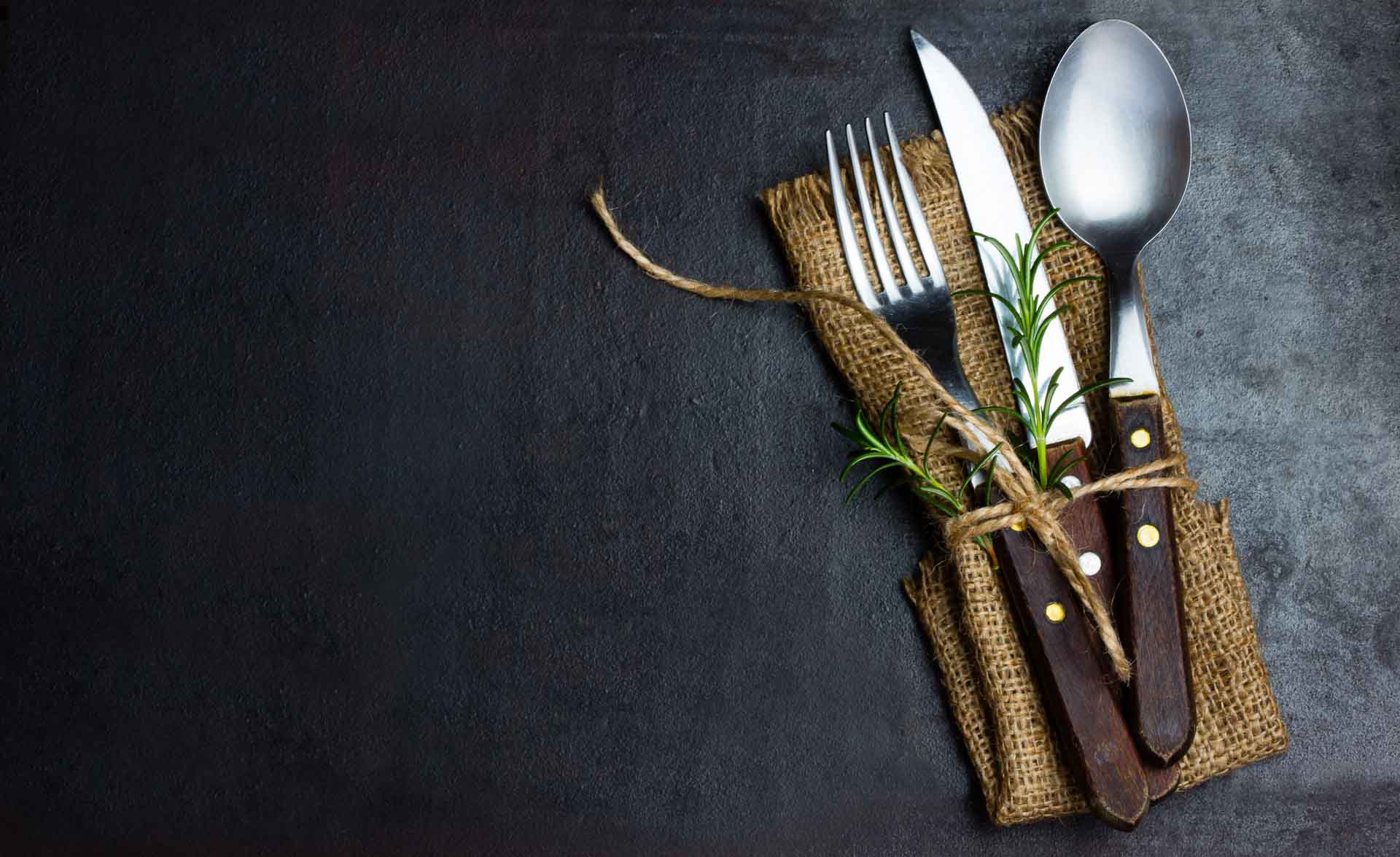 Rustic vintage set of cutlery knife, spoon, fork. Black background.