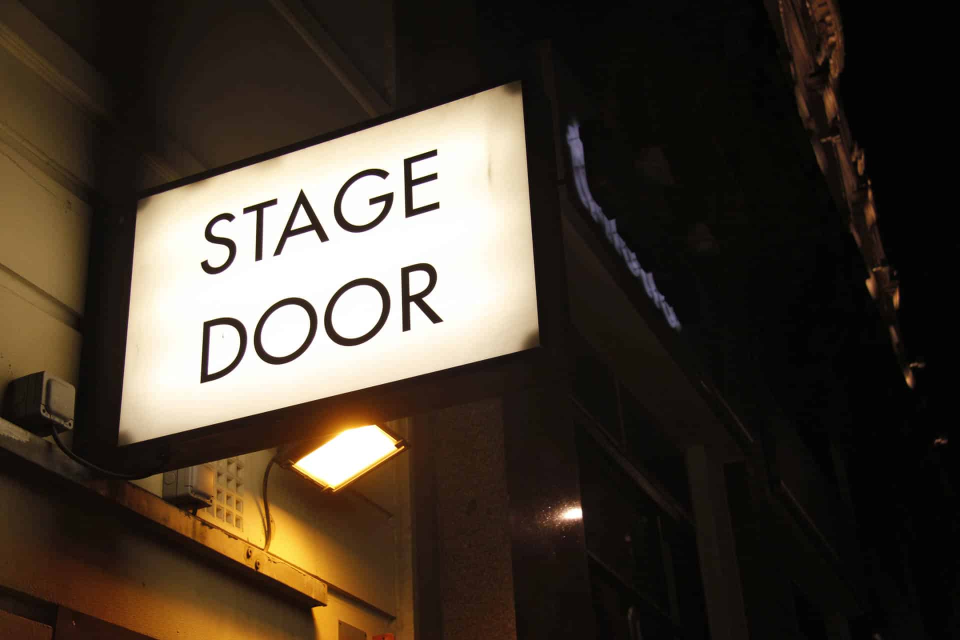A Stage Door Sign Above A Theatre/Pub Building