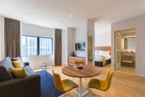 Rotterdam Apartment Living room and bedroom with yellow pillows and bed throw