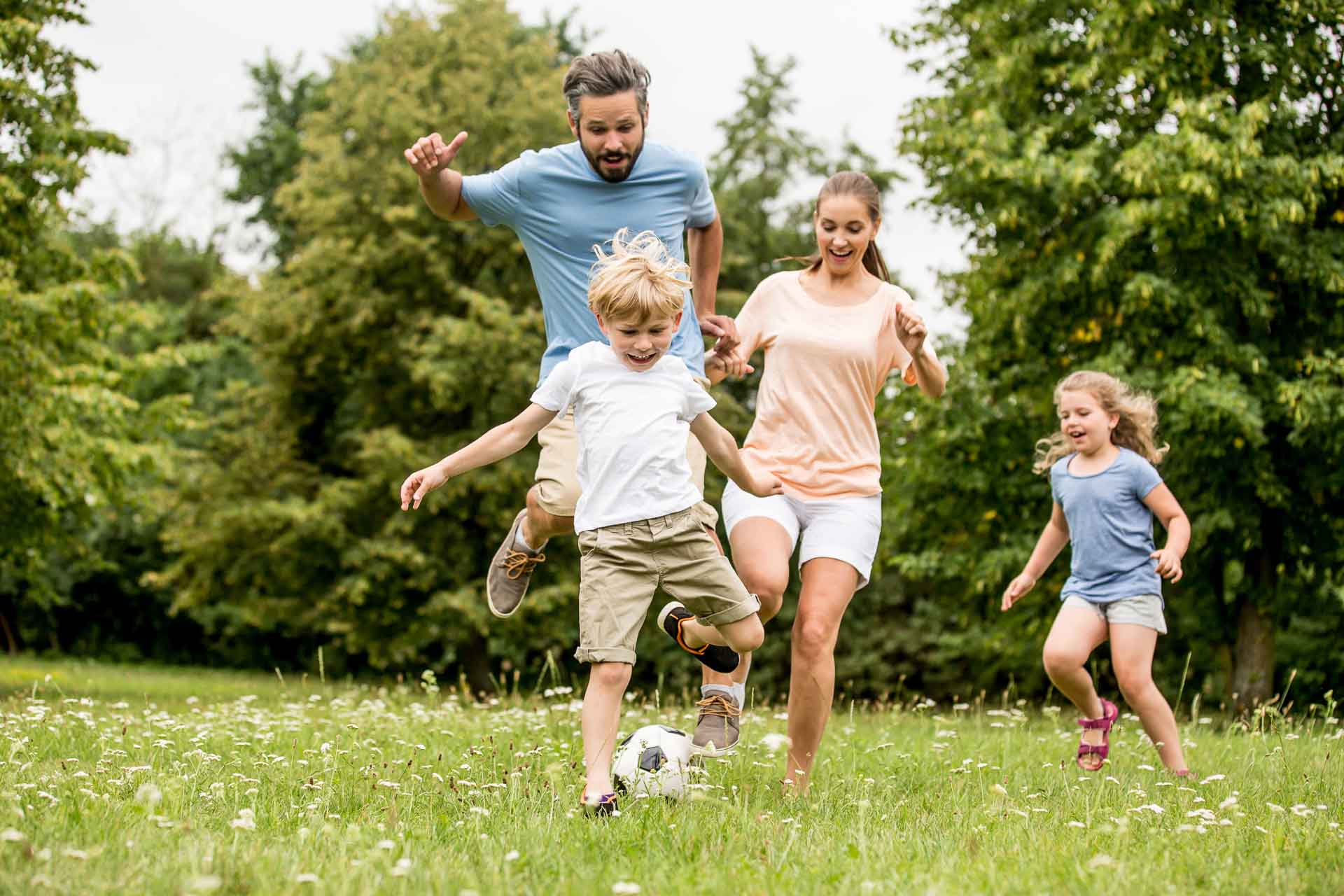 Aktive Familie spielt in ihrer Freizeit Fußball