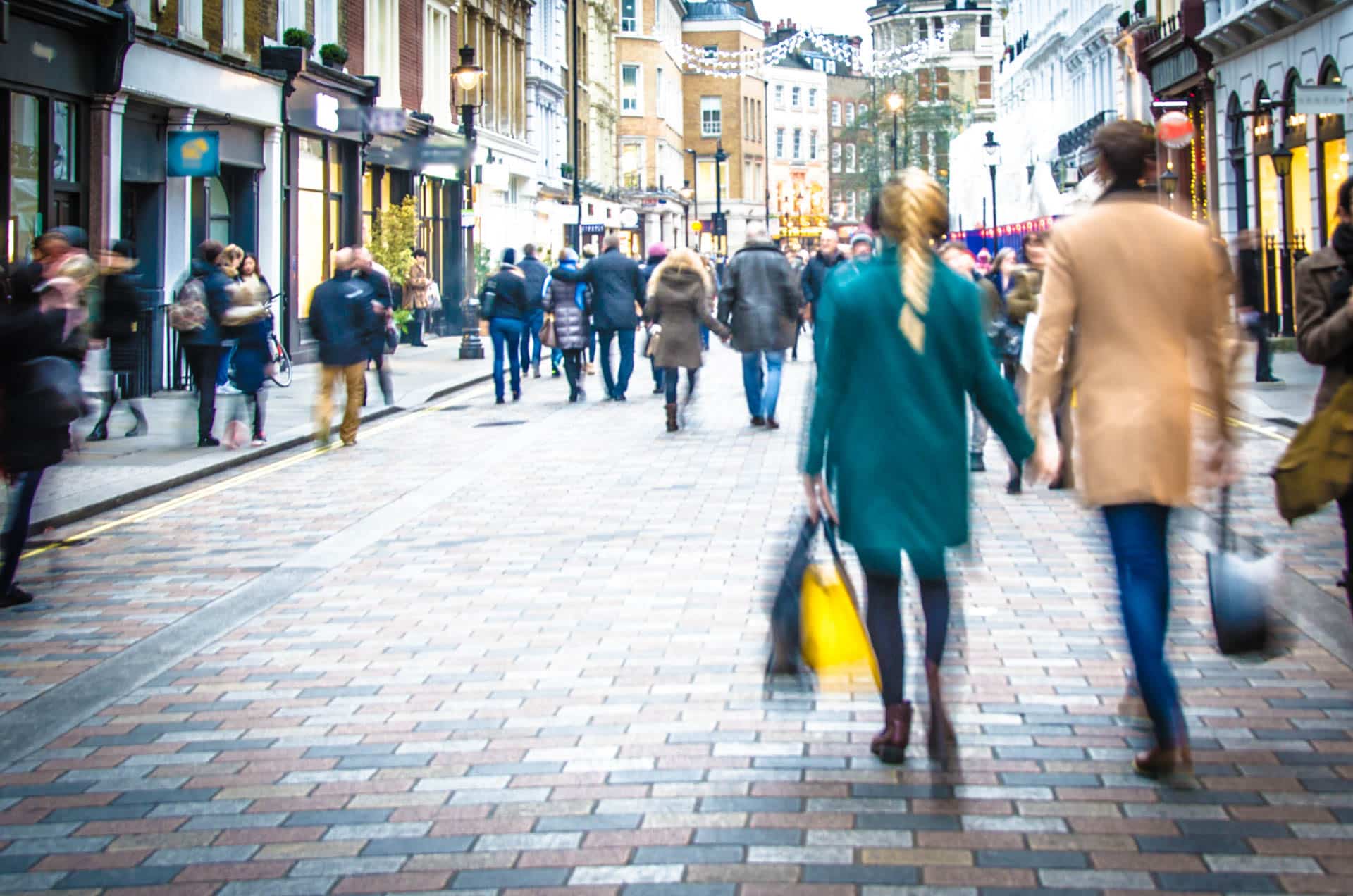 Des acheteurs se tenant la main dans une rue animée de Londres