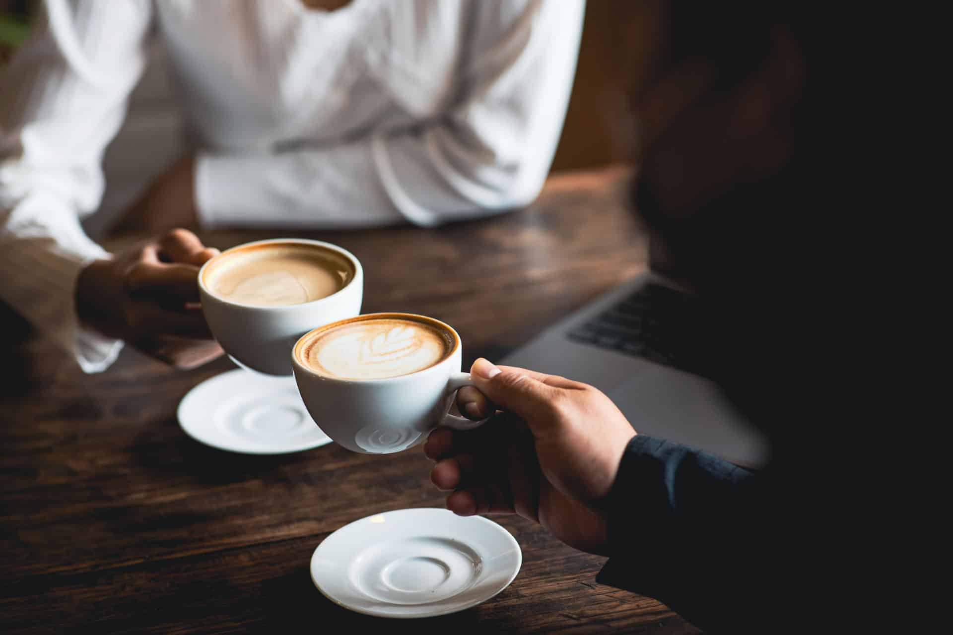 Zwei Personen mit Kaffee in der Hand
