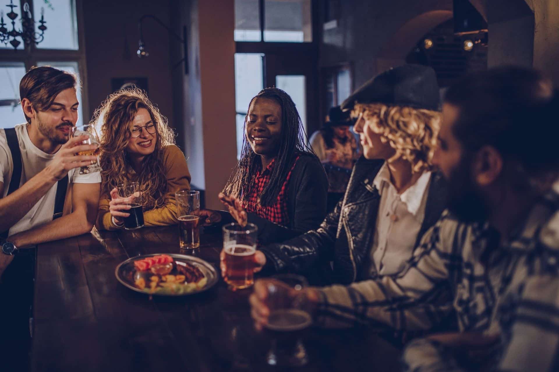a group of people sitting around a table with drinks