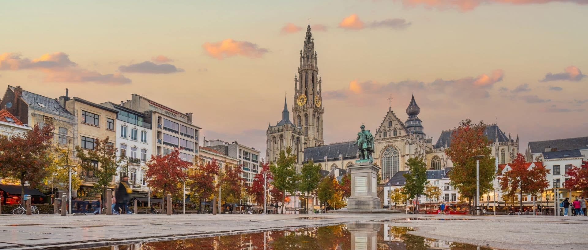 View of Antwerp’s Grote Markt with the Cathedral of Our Lady, Rubens statue, and autumn reflections.