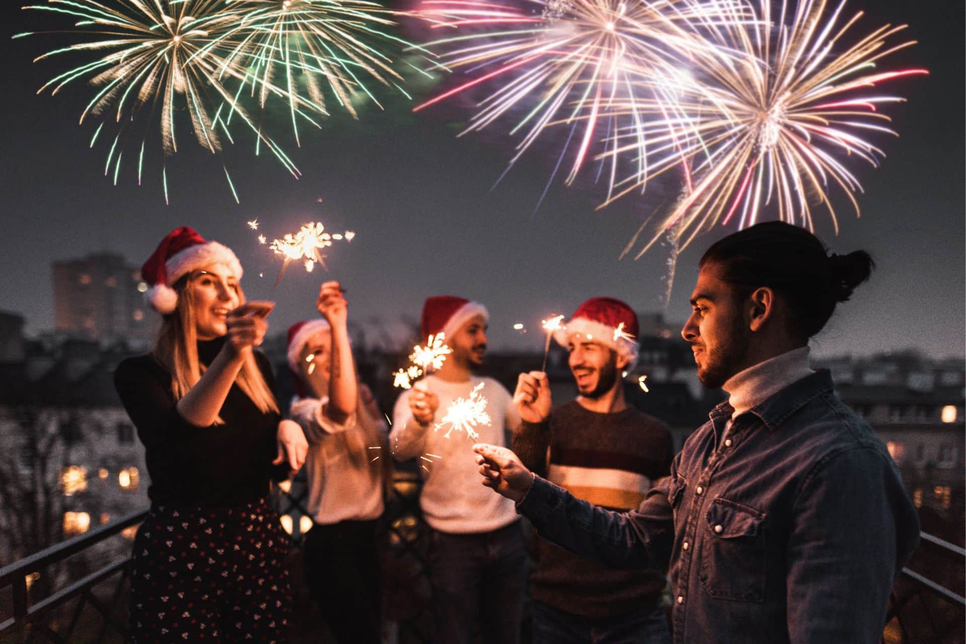 Group of friends lighting firework on new year