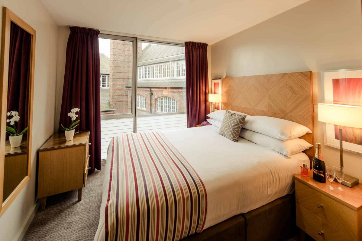 Large bedroom with double bed and city views at PREMIER SUITES Liverpool