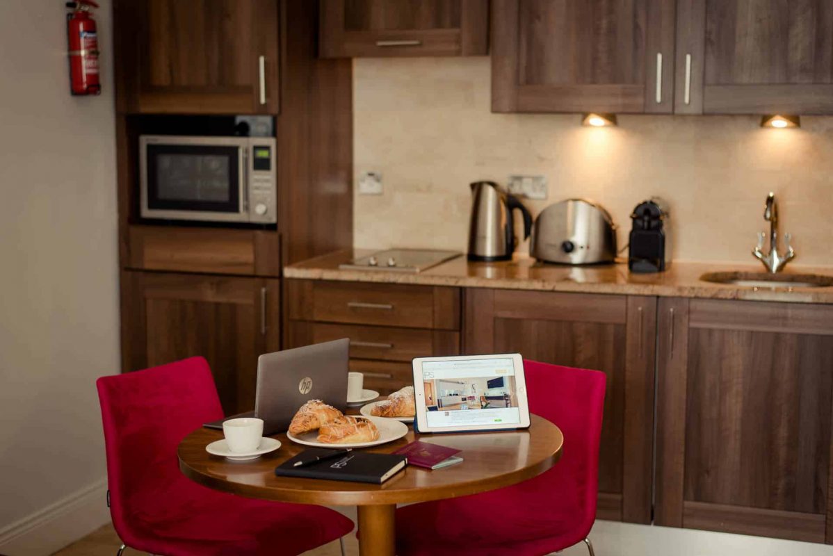 PREMIER SUITES PLUS Dublin Leeson Street breakfast and laptops on kitchen table one bed